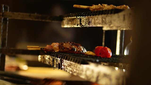 Cooking meat, tomatoes and mushrooms on grill at the kitchen with flame