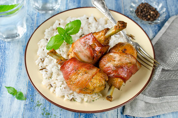 Bacon wrapped chicken legs with rice garnish