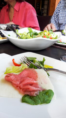 Carpaccio salmon with salad, cheese and appetizers at restaurant