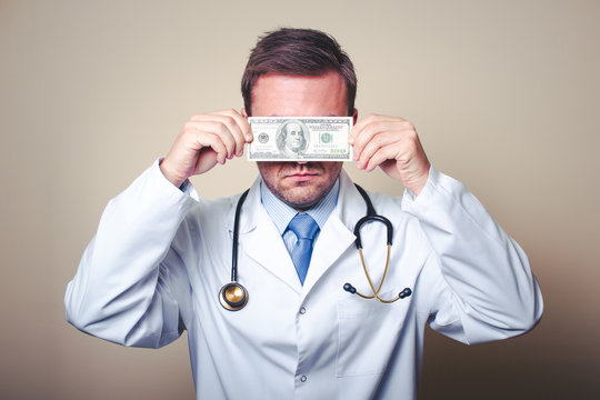 Doctor in uniform with a hundred dollar bill covering his eyes.