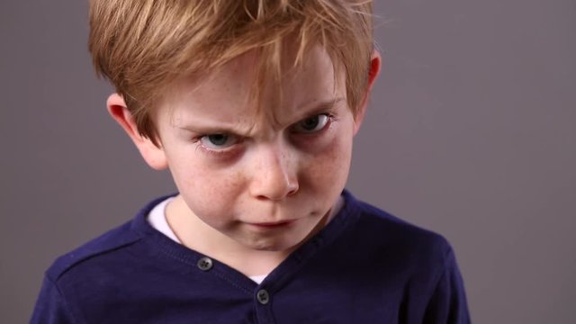 cute young child showing how to look mad and conflicted
