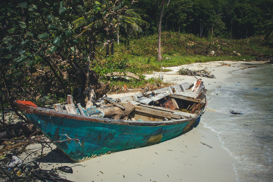 Abandoned wooden boat on the sea shore.