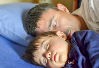 Fototapeta na wymiar Baby girl sleeping in bed with her father