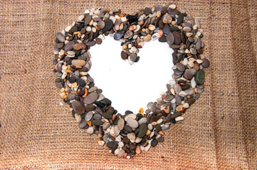 Sea stones laid out in the shape of a heart. Place for text.