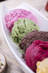 Pistachio ice cream with multi-colored balls on white ware