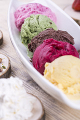 Strawberry, pistachio, chocolate, cowberry and banana ice cream in white glasswares