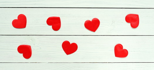 red hearts symbol of love on a white wooden background