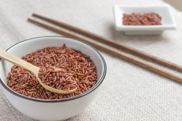 Raw red wild rice in ceramic bowl and Chinese chopsticks