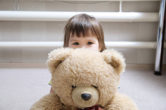 Kid Hugging Teddy Bear Indoor In Her Room, Devotion Concept, Child Hiding Behind Toy