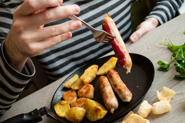 man eating a fried sausage, food concept,