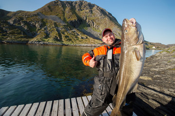 Happy fisherman showing thumb. The huge fish. The horizontal pos