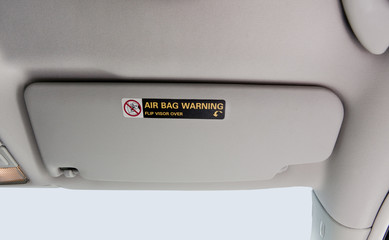 Beige car visor with air bag warning.