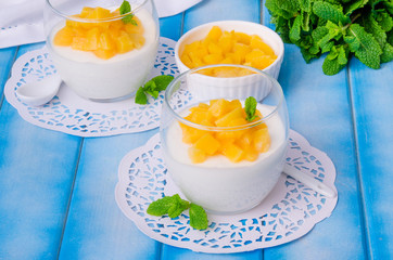 Bavarian cream mousse with vanilla and peaches in syrup in a glass