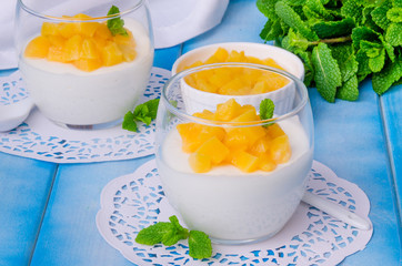 Bavarian cream mousse with vanilla and peaches in syrup in a glass
