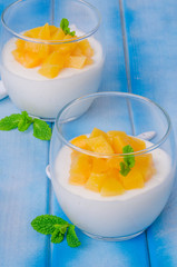 Bavarian cream mousse with vanilla and peaches in syrup in a glass