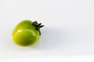 Green tomato on white background.