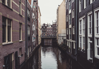 Fototapeta na wymiar Canal between buildings in Amsterdam