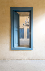 Opened blue wooden window with vintage plaster wall
