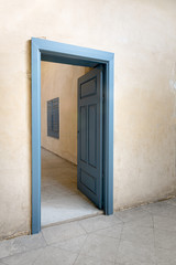 Blue wooden vintage door at an old historic building with plaster wall, Medieval Cairo, Egypt