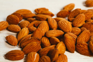 handful of almonds on a white wooden background