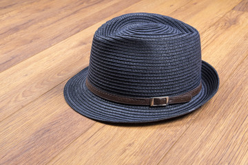 Fototapeta na wymiar Men's Stylish Straw Hat on Wood Flooring