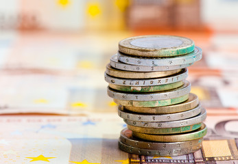 Money. Euro coins against euro banknotes background