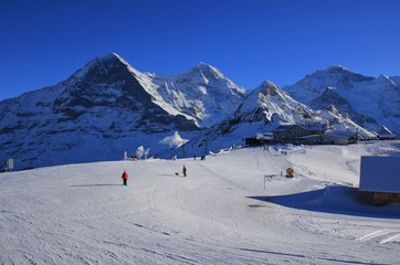 Ski slope and snow covered mountains Eiger, Monch, Lauberhorn and Jungfrau