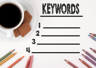 Keywords blank list. White desk with a pencil and a cup of coffee.