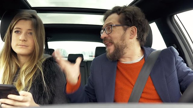Father driving car angry with daughter on the phone addicted/Father and daughter in car fighting