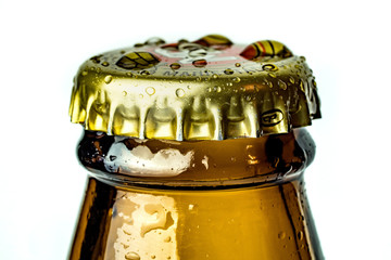 Heavy enlarged closeup of a bottle neck from a beer with moisture on the cap