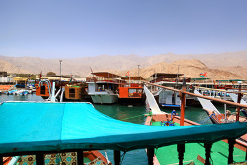 Fototapeta na wymiar View on a boats docked at the little harbour in Oman