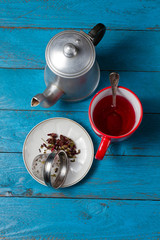 Red tea, teapot and tea leaves