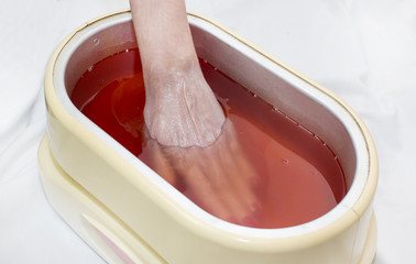 Process paraffin treatment of female hands in beauty salon 