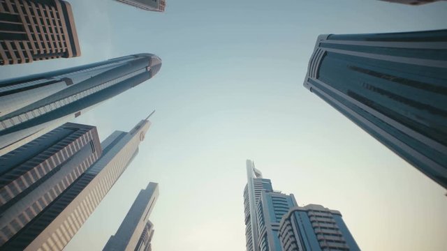 Skyscrapers with stained-glass facades in the UAE. Stone jungle: modern architecture and high buildings in Dubai. Busy vehicular traffic. The modern and developed metropolis. Urban.