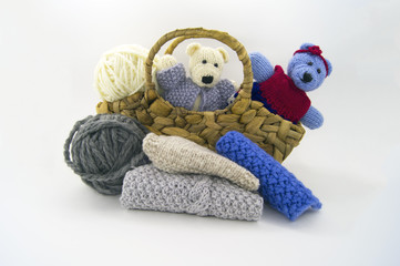 Knitted bears in a basket with balls of yarn