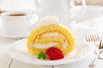 Biscuit roll with strawberry jam, and strawberries.