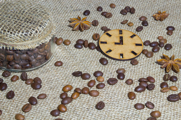 Fototapeta na wymiar Roasted coffee beans, icon clock, star anise and jar of coffee o