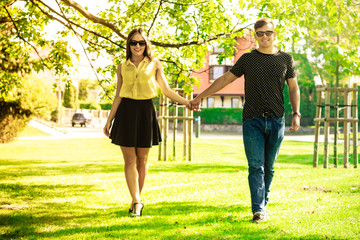 Couple holding hands in park.