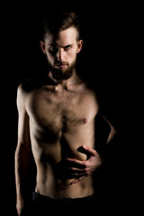 Fototapeta na wymiar slim bearded man with thin bare torso isolated on black