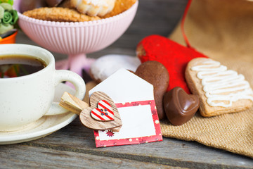 Heart shaped cookies and chocolate candies (big and small as couple), cup of coffee, bouquet of...