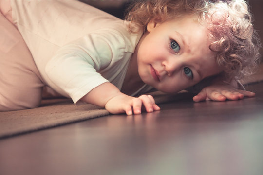Curious Cute Child Hiding Under The Bed In Kids Room And Looking Scared