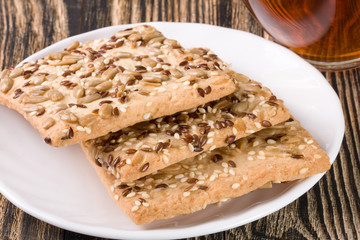 crispy bread with seeds of sunflower, flax and sesame seeds on a dark wooden background