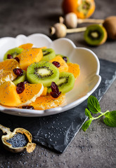Fruit salad with Minneola tangelo, kiwi, persimmons, cranberries, sprinkled with poppy seeds