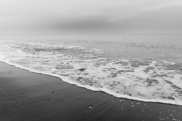Obraz premium The sea washes the beach. Black and white photo shows a beautiful abstract atmosphere.