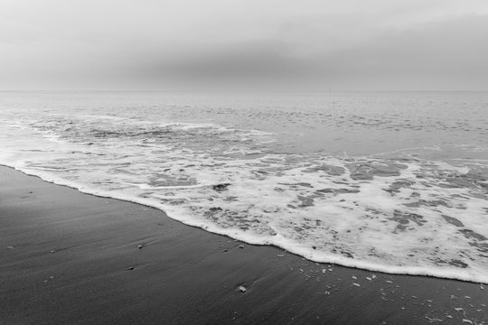 Fototapeta The sea washes the beach.  Black and white photo shows a beautiful abstract atmosphere.