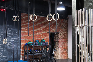 Contemporary interior of a cross-fit gym, red brick wall with sport equipment