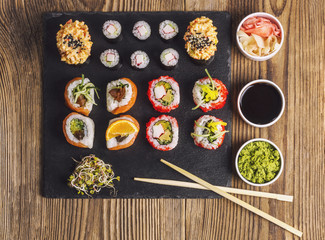Sushi served on a black stone, with wasabi, soy sauce and ginger