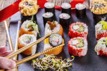 Close up of chopsticks taking a sushi roll