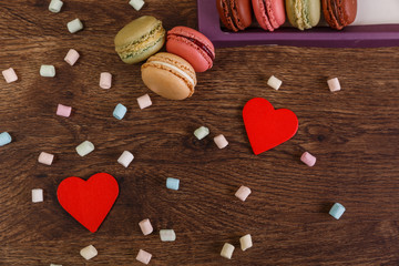 Macaroon cakes with love heart and marshmallows. Valentines day concept. Colorful almond sweet cookies. Wooden rustic board.