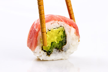 Sushi roll in chopsticks isolated on a white background